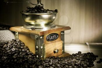 coffee grinder, beans and sacking on wood in night