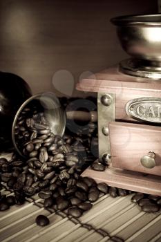 coffee beans, pot and grinder on sacking in sepia