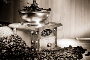 coffee beans and grinder on sacking in old sepia