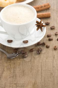 cup of coffee with beans on wood background texture