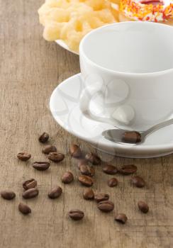 empty cup of coffee with beans on wood background texture