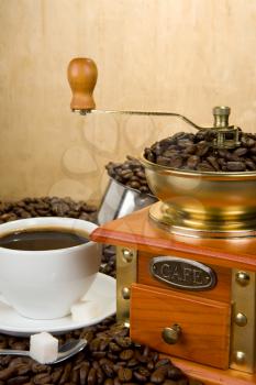 coffee beans, cup and grinder on wood texture