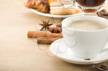 cup of coffee with beans on wood background