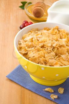 Bowl of corn flakes and milk on wood background