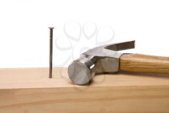 hammer and nail isolated on wood brick on white background 
