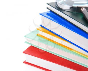 pile of new books and magnifying glass isolated on white background