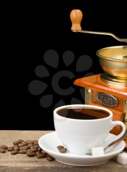 cup of coffee and grinder on beans