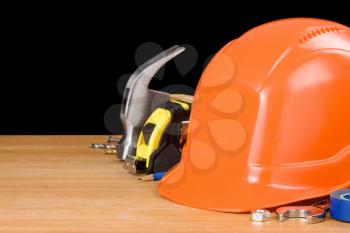 tools and helmet isolated on black background at wood