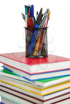 pile of new books and holder basket in pens isolated on white background