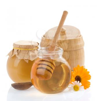 jar of honey and flowers isolated on white background