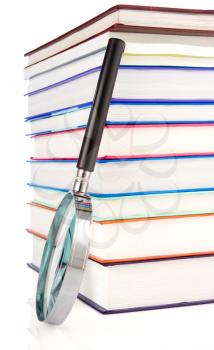 pile of new books and magnifying glass isolated on white background