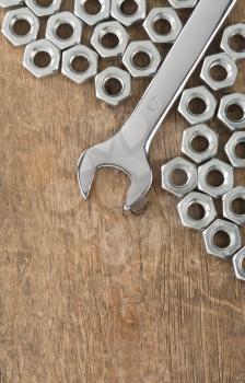 wrench and nut tool on wood background