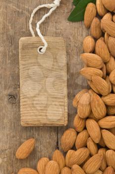 nuts almond and tag price on wood background