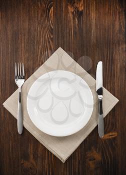 plate, knife and fork  on wooden background