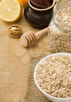 cereals oat flake and healthy food in plate on wood background