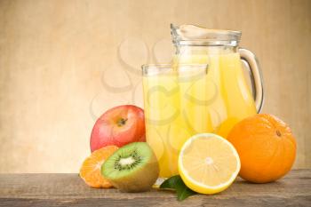 fresh fruits juice in glass and slices on wood background