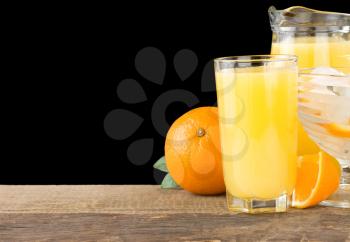 juice and oranges isolated on black background