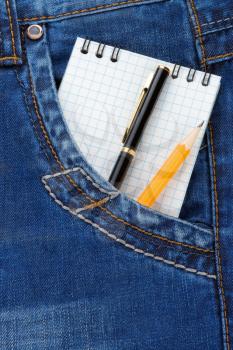 notebook and pencil on jeans packet background