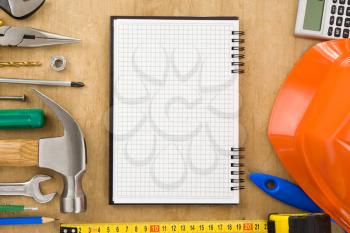 tools and notebook on wood texture background