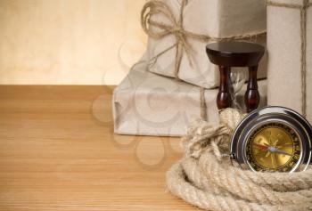 parcel wrapped and compass on wood background