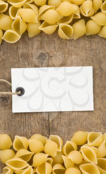 raw pasta and price tag on wood as background