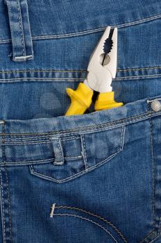 yellow pliers in pocket jeans