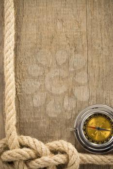 ship ropes and compass on wooden background texture