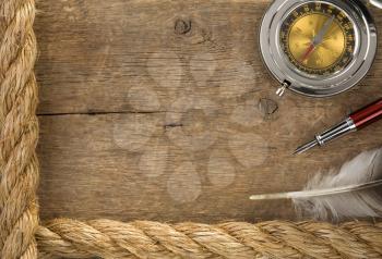 ship ropes and compass at old wooden background