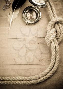 ship ropes and compass on wood background