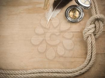 ship ropes and compass on wood background board