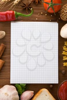 notebook for cooking recipes and spices on wooden table