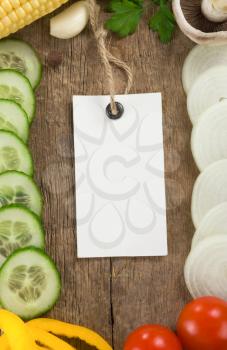 vegetable food and price tag over wood background texture