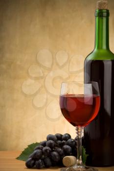 red wine in glass and bottle on wood background