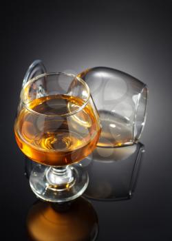 brandy in glass on black background