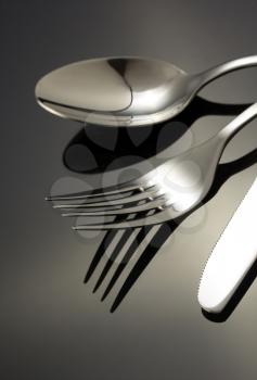 knife, spoon and fork on black background