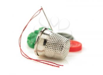 sewing thimble and thread with needle isolated on white background