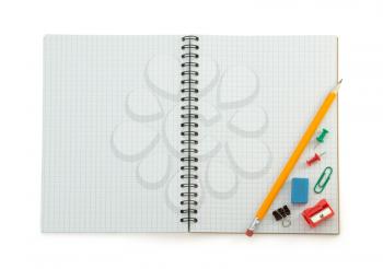 school supplies on checked notebook isolated at white background