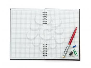 school supplies on checked notebook isolated at white background