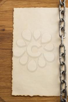 chain and old vintage ancient paper at wooden background