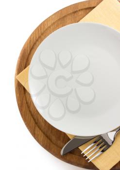 plate, knife and fork at cutting board on white background