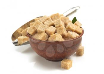 brown sugar cubes in bowl isolated on white background