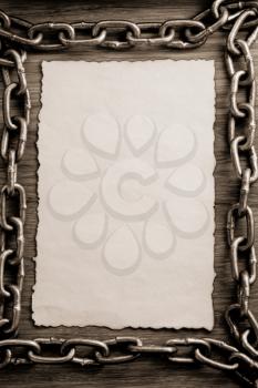 metal chain and old vintage ancient paper at wooden background