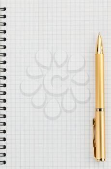 pen and checked paper of notebook as background