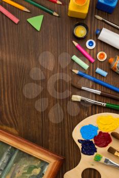 paint supplies and brush on wooden background