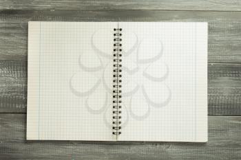 checked notebook on wooden background