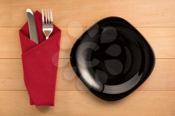 knife and fork with napkin on wooden background