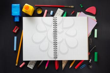 school supplies and notebook on wooden background