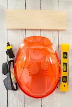 construction helmet and safety glasses on wooden background