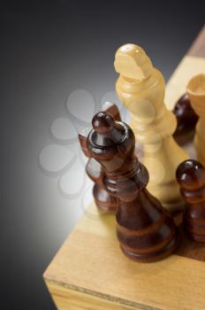 chess figures and board at black background