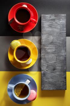 cup of coffee, cacao and tea at colorful paper background